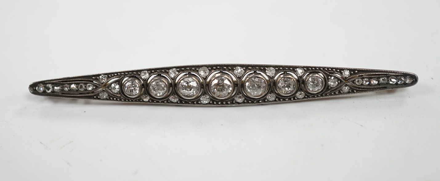 An Eastern European yellow metal (stamped 585) and white metal (stamped 875) and graduated diamond set bar brooch, 65mm, gross 5.1 grams. Condition - fair